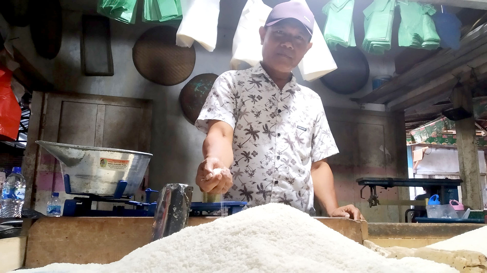 HARGA NAIK: Paidi hendak menimbang beras yang harganya tengah naik sejak dua bulan lalu di Pasar Genteng 2, Desa Genteng Kulon, Kecamatan Genteng Minggu(19/2).