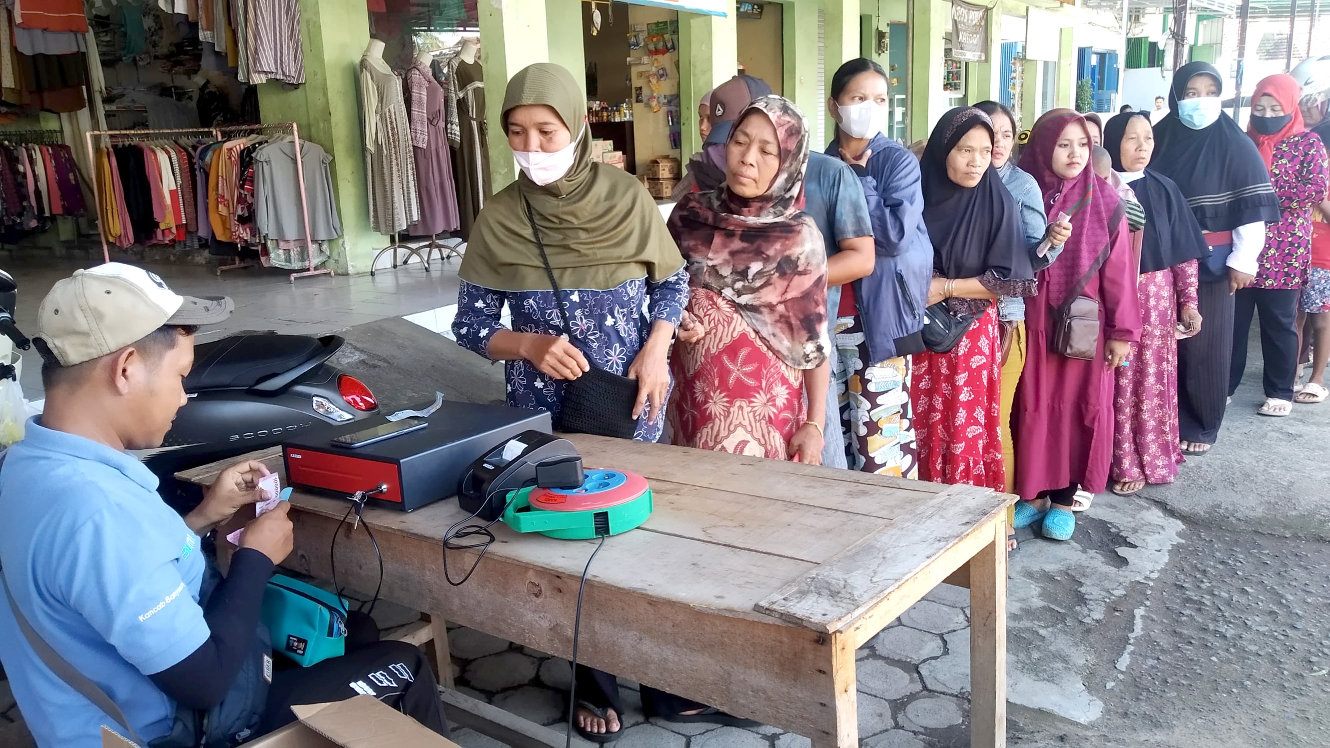 TERTIB: Warga baris mengantri membeli beras dan gula dalam pasar murah di Pasar Sempu Rabu (21/2).