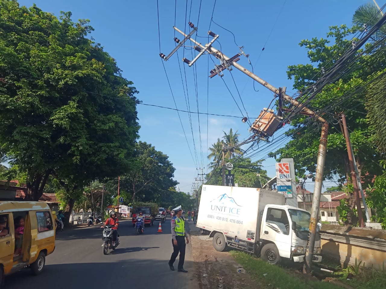 PATAH: Truk boks bermuatan es kristal menabrak tiang listrik di depan Hotel Mirah, Jalan Yos Sudarso, Kelurahan Klatak, kemarin siang (27/2).