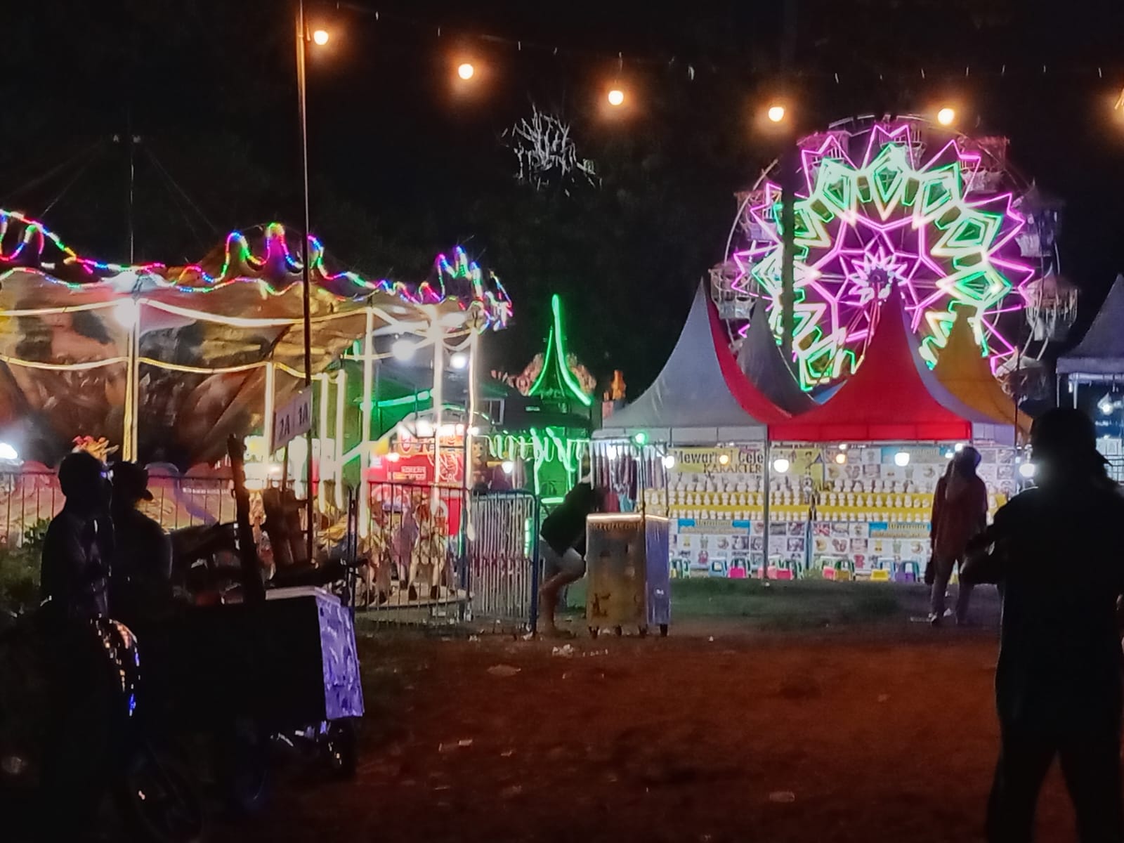 Wahana keranjang putar di Pasar Malam Kalipuro tampak menyala dihiasi lampu warna-warni. (Irwan/RadarBanyuwangi.id)