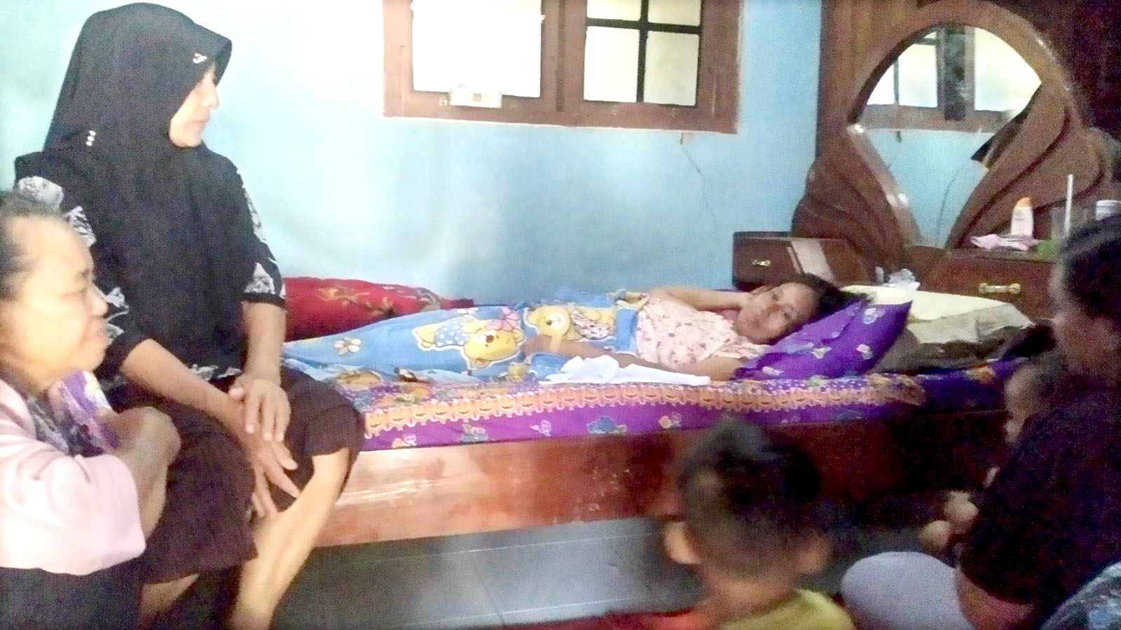 PEMULIHAN: Sumiati berbaring di kasur dijenguk kerabatnya di Dusun Sidomulyo, Desa Jambewangi, Kecamatan Sempu Rabu (28/2).