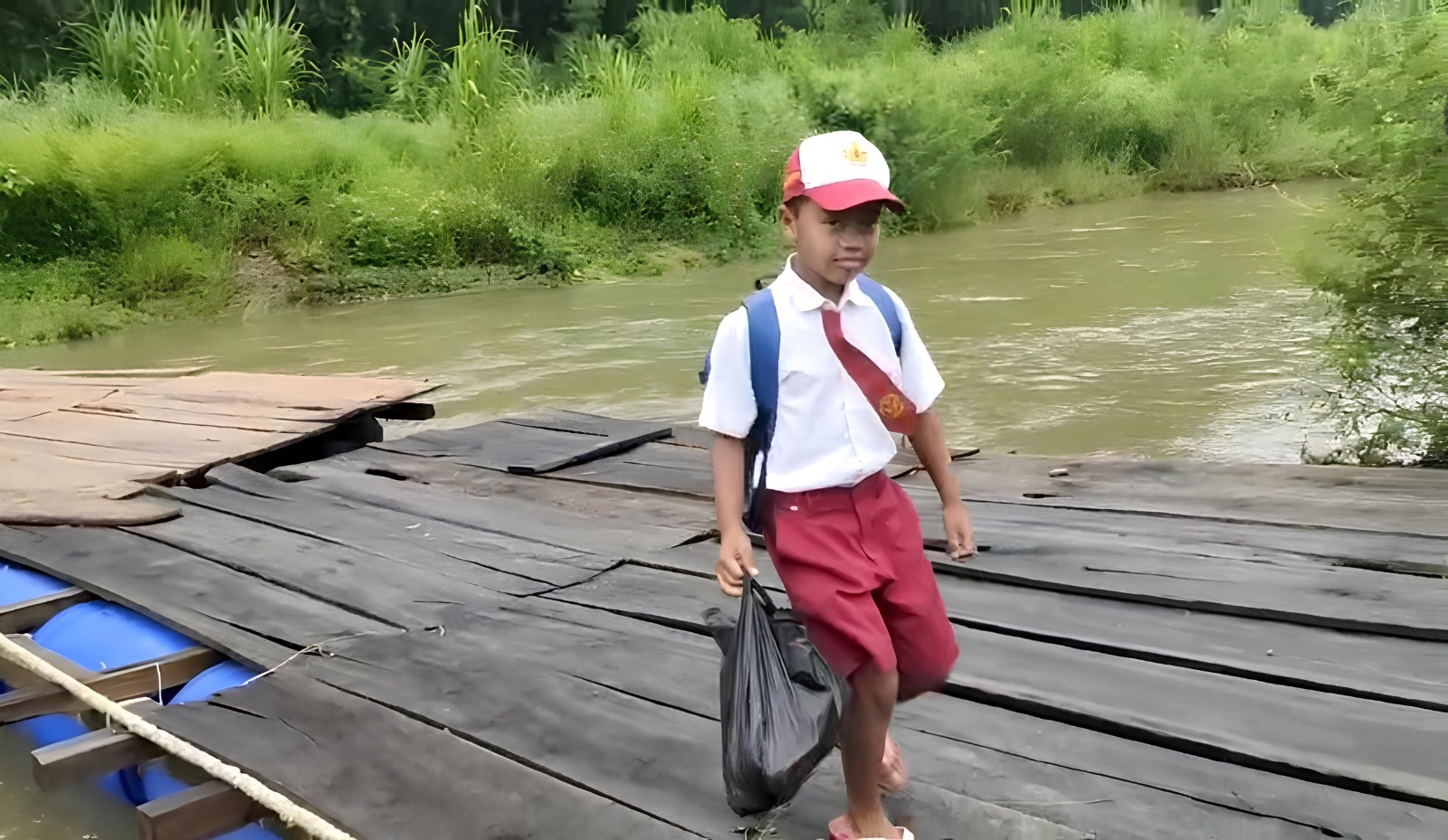 MENYEBERANG: Siswa berangkat sekolah harus berjalan kaki dengan melewati jembatan getek di Dusun Sukamade, Desa Sarongan, Kecamatan Pesanggaran Jumat(1/3).