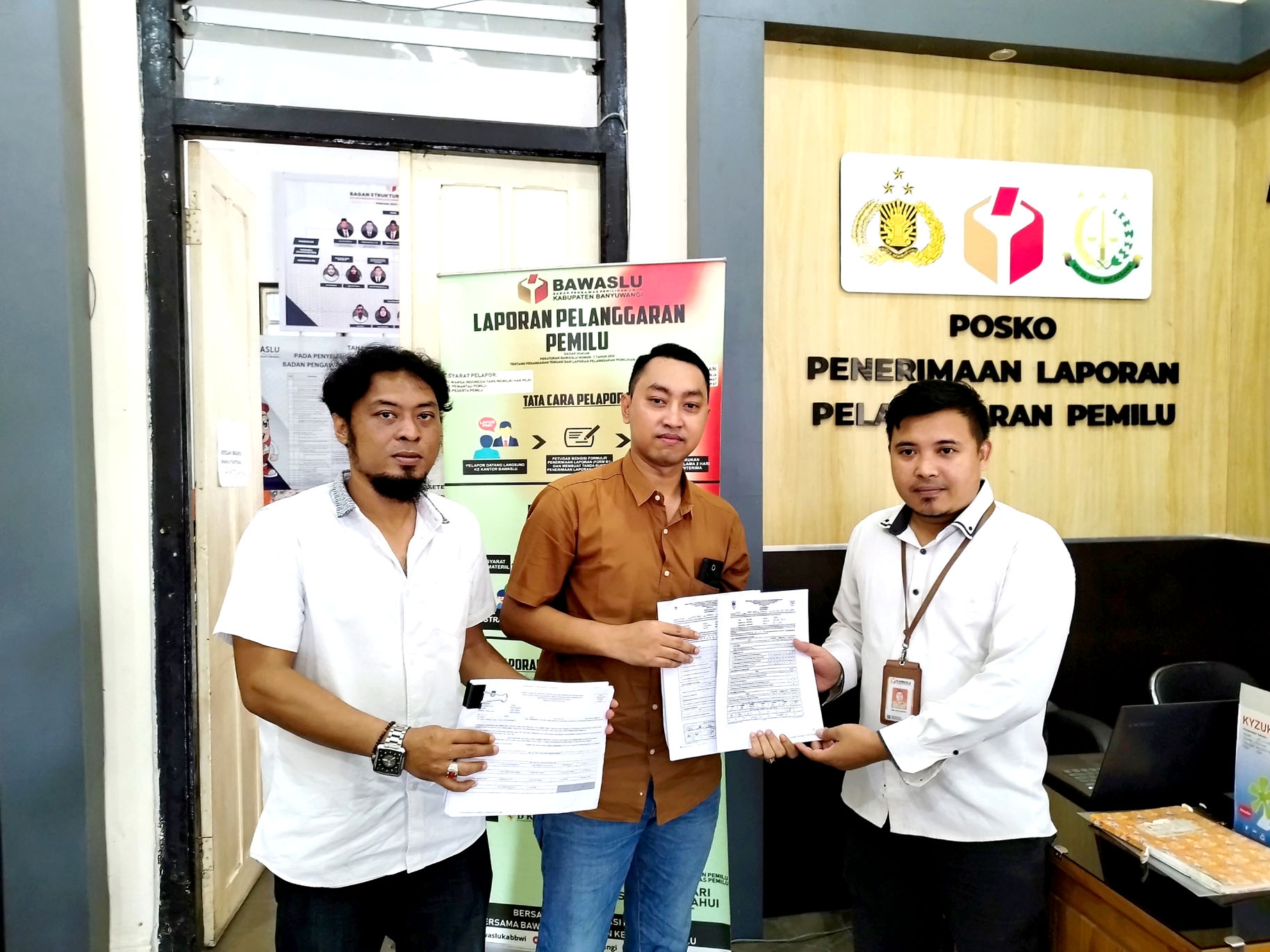 LAPORAN: Tim hukum Marcelinus, Muhammad Habli Hasan (kiri) dan M. Yusuf Febri (kanan) menunjukkan bukti C plano, C hasil, dan D hasil di kantor Bawaslu Banyuwangi Jumat (1/3).