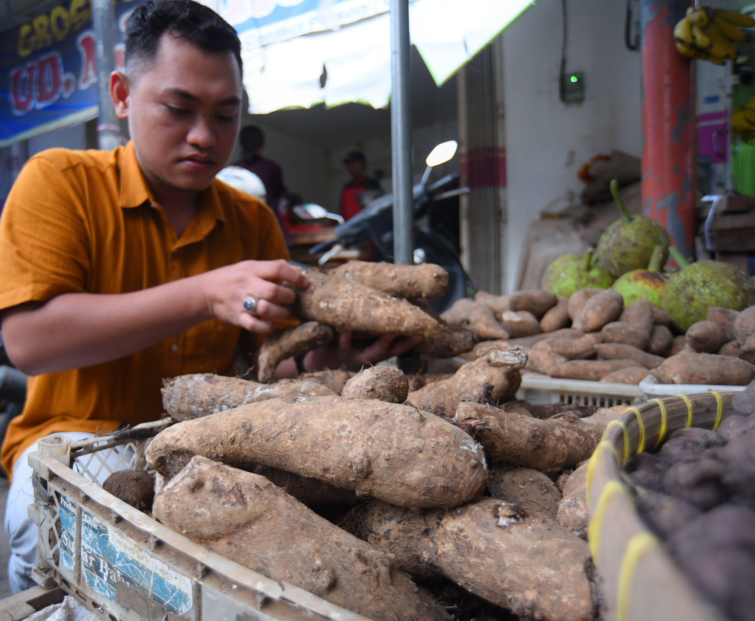 MBOTE: Benny Pambudi membeli ubi talas di Pasar Banyuwangi kemarin.