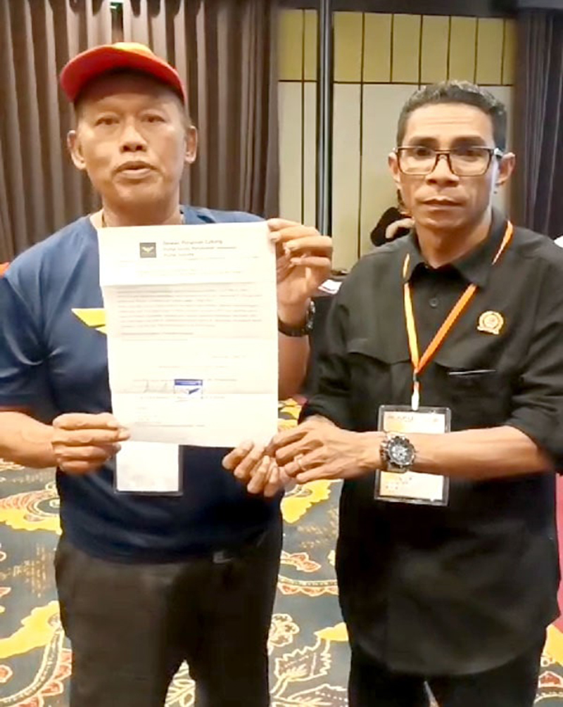 TOLAK HASIL PLENO: Ketua Partai Garuda Yusuf Hidayat menyerahkan surat pernyataan sikap penolakan tanda tangan kepada Ketua Bawaslu Adrianus Yansen Pale di ruang meeting El Hotel Banyuwangi Minggu (3/