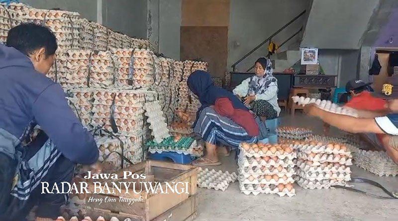 BELANJA KEBUTUHAN DAPUR: Salah satu warga mengangkut telur dari salah satu toko di Pasar Mimbaan, Kecamatan Panji, Situbondo, Senin (4/3).