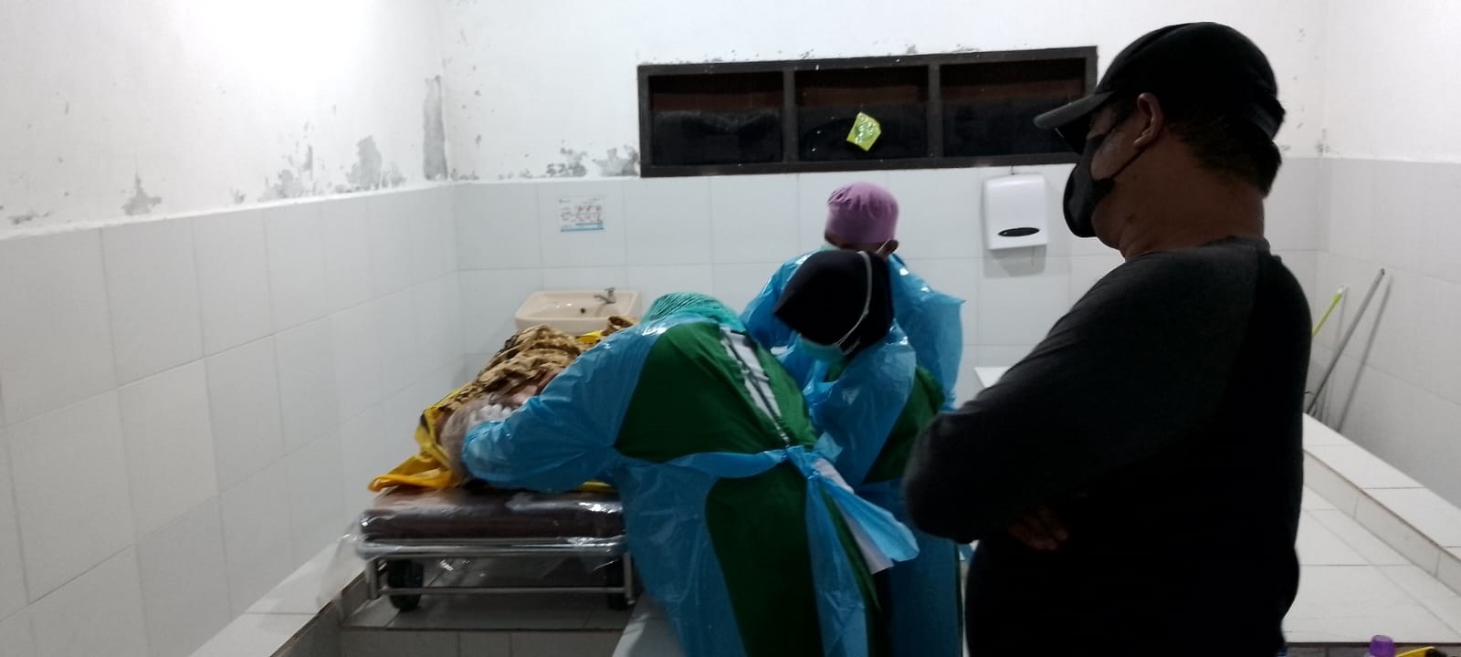 PEMERIKSAAN: Jenazah Tumini yang dibawa ke kamar mayat RSUD Genteng diperiksa oleh petugas medis pada Rabu (6/3) malam.