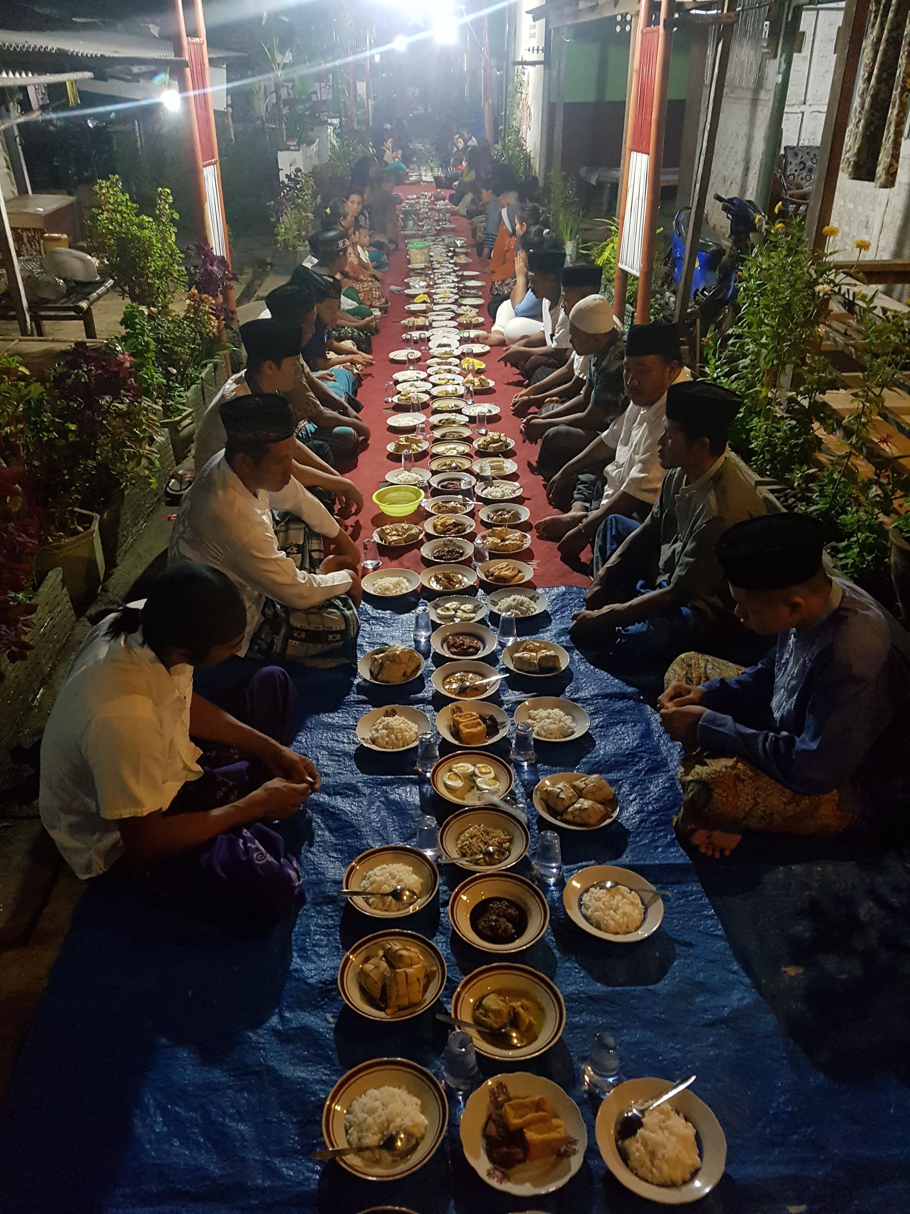 BERSYUKUR: Warga berdoa dan makan bersama dalam acara selamatan Penampan Poso di Desa Kemiren, Kecamatan Glagah, Banyuwangi.
