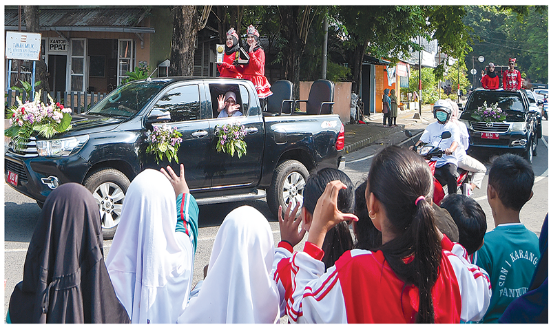 TANAMKAN KEBANGGAAN: Siswa menyaksikan rombongan peserta kirab Piala dan Plakat Adipura 2023 saat melintas di Jalan Pierre Tendean Banyuwangi Jumat (8/3).