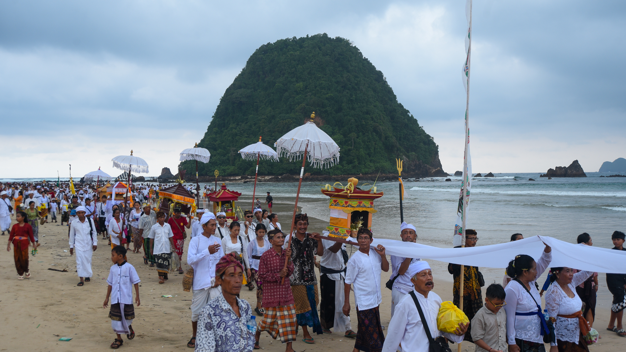 DIIRINGI MUSIK BALEGANJUR: Umat Hindu berjalan menyusuri Pantai Pulau Merah usai melaksanakan Melasti di Pura Tawang Alun, Dusun Pancer, Desa Sumberagung, Kecamatan Pesanggaran, Jumat (8/3).