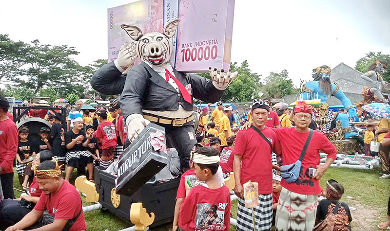 TRADISI: Ogoh-ogoh koruptor diarak dalam pawai menjelang Hari Raya Nyepi di lapangan Desa Sumbermulyo, Kecamatan Pesanggaran, Minggu (10/3).