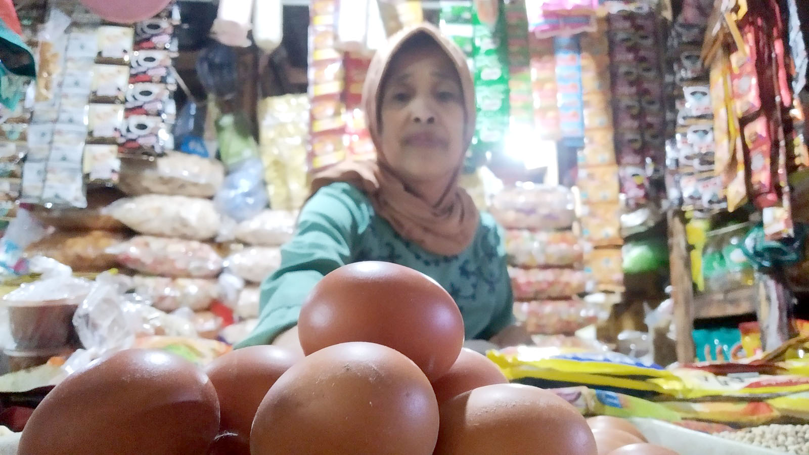 BERHARAP TERJUAL: Halimah menata telur dagangannya sambil menunggu pembeli di Pasar Induk Genteng 1, Desa Genteng Kulon, Kecamatan Genteng Selasa (12/3).