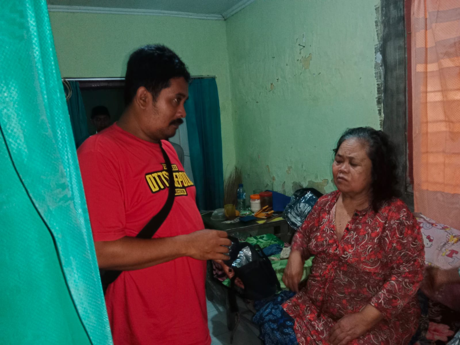 BOLONG: Anggota Reskrim Polsek Glagah menunjukkan plafon rumah milik Saenah di Desa Bakungan, Kecamatan Glagah, yang dibobol maling Selasa (12/3). Korban pencurian, Saenah, dimintai keterangan oleh an