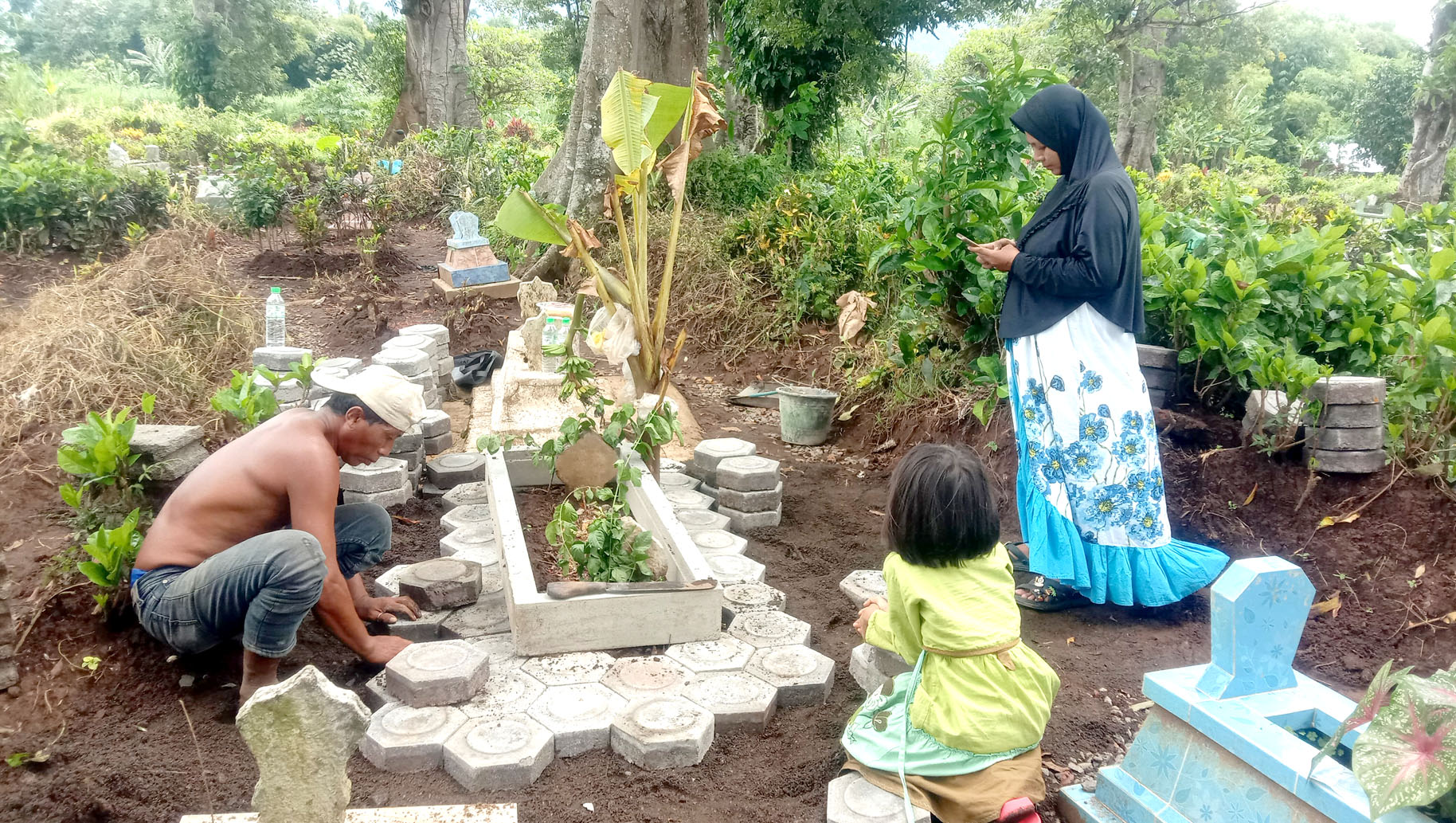 PERBAIKAN: Suyanti (kanan) mendampingi warga yang memperbaiki makam Bintang Balqis Maulana di Dusun Kendenglembu, Desa Karangharjo, Kecamatan Glenmore Jumat (15/3).
