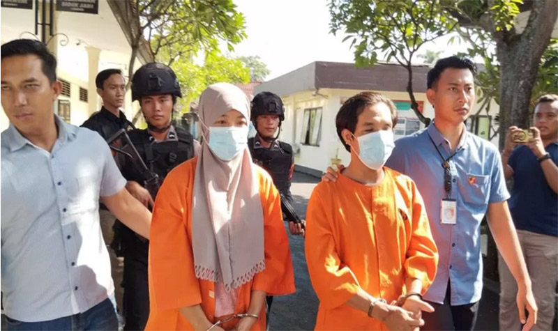 MENUJU SEL: Ali Imron dan Marita Mayasari saat digelandang menuju sel tahanan Mapolres Jembrana