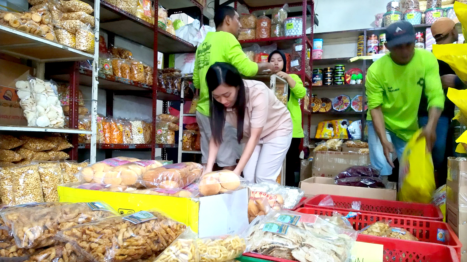 SIBUK: Eli Mayasari menata kue Lebaran di toko Dua Saudara depan Pasar Induk Genteng 1, Desa Genteng Kulon, Kecamatan Genteng Senin (18/3).