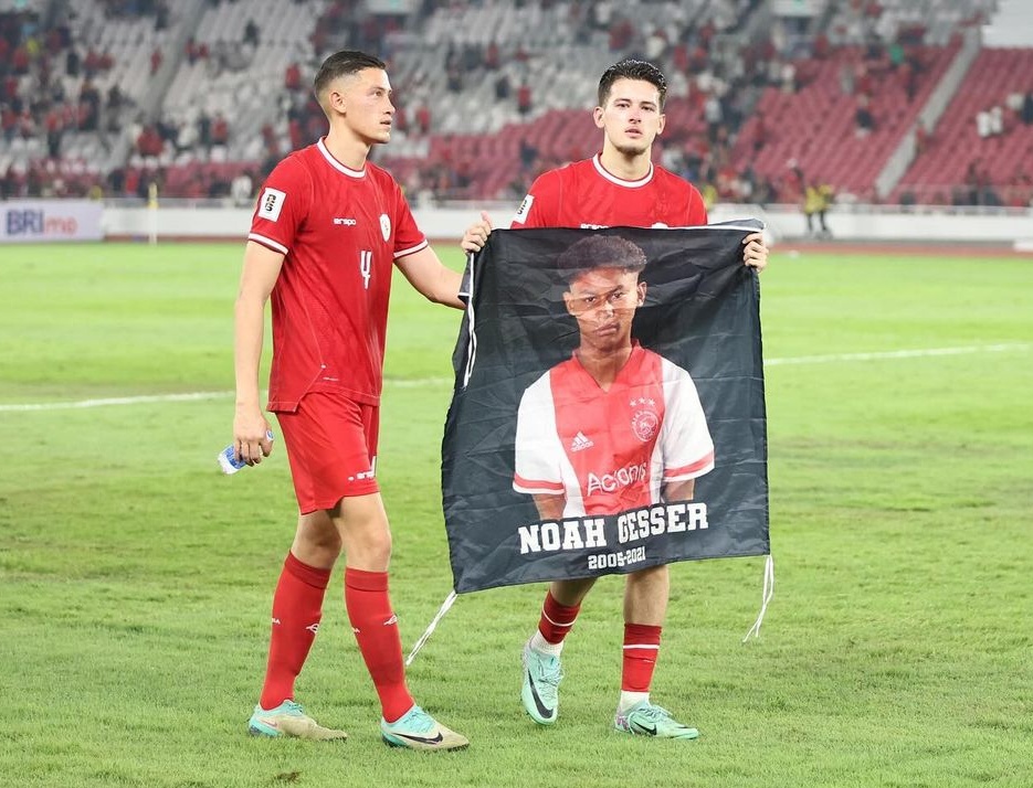 Justin Hubner memegang spanduk bergambar sahabatnya