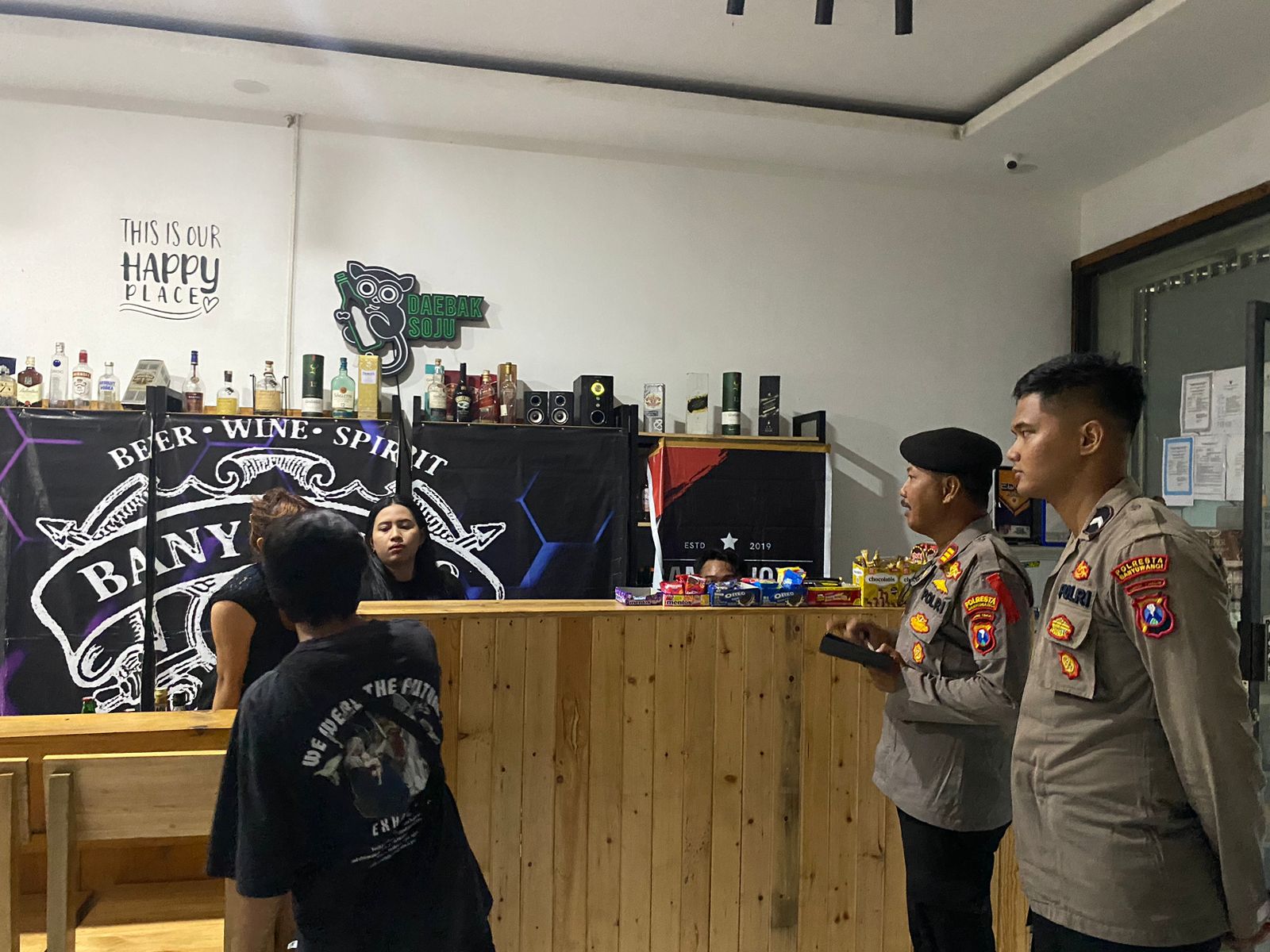 BERANI BUKA: Personel Sabhara mengecek toko miras Banyu Joyo yang berlokasi di sudut jalan dekat traffic light Jalan MT Haryono, Banyuwangi, Rabu sore kemarin (20/3).