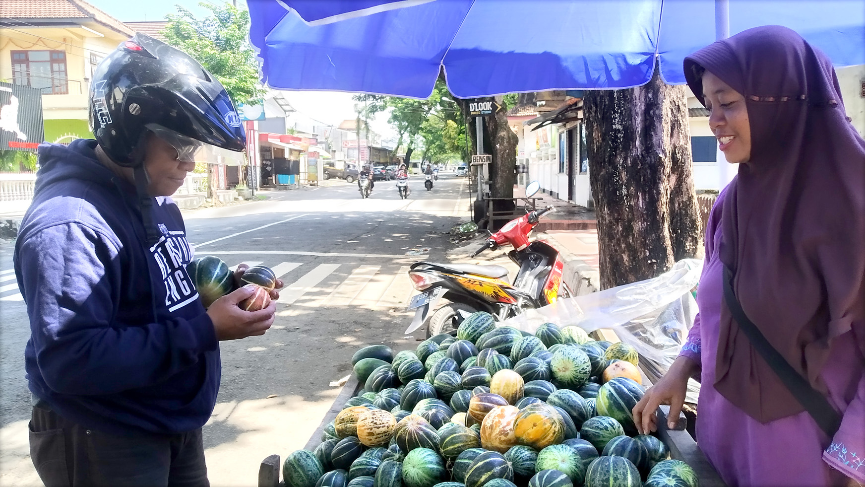 LARIS: Supriyatin melayani pelanggan yang membeli buah blewah di Jalan Wahid Hasyim, Desa Genteng Kulon, Kecamatan Genteng Jumat (29/3).