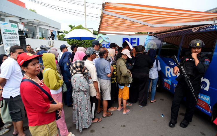 SANGU LEBARAN: Salah seorang warga menunjukkan uang baru di tempat penukaran yang disiapkan BI di pintu masuk Pelabuhan ASDP Kertapang Senin (1/4).