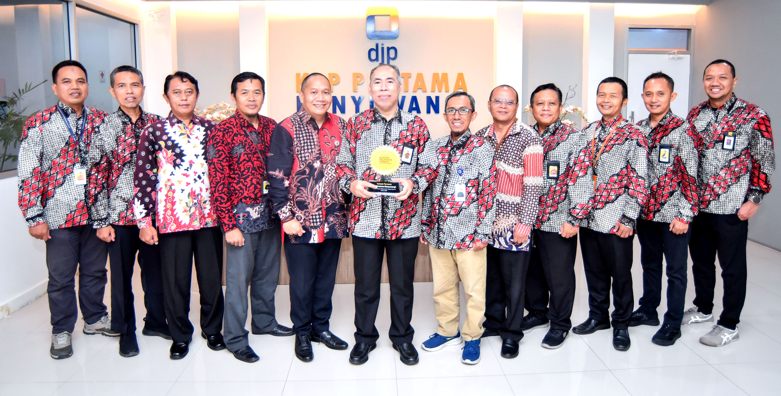 BERPRESTASI: Ahmad Fudholi didampingi para leader KPP Pratama Banyuwangi menunjukkan piala lambang supremasi Kantor Pelayanan Terbaik Pertama Tahun 2023 dari Kanwil DJP Jatim III.