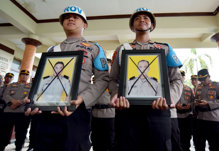 UPACARA PTDH IN ABSENTIA: Foto Bripka Alexandra Febriano dan Bripka Gusde Santoso diberi tanda silang dalam pelaksanaan PTDH di Mapolresta Banyuwangi Selasa (2/4).