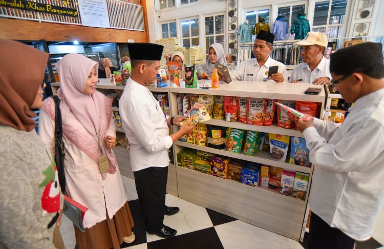 INSPEKSI MENDADAK: Petugas Kemenag Banyuwangi mengamati label halal pada kemasan makanan yang dijual di gerai Deli Bakery Kamis (4/4).