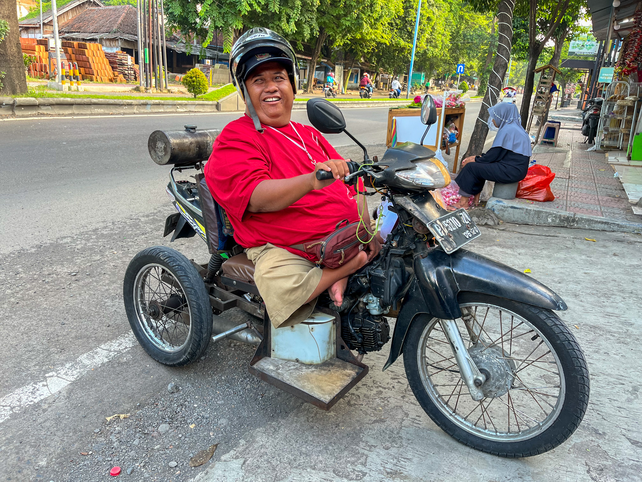 KREATIF: Juru parkir penyandang disabilitas tetap bekerja di Banyuwangi, dengan bantuan motor modifikasi beroda tiga.