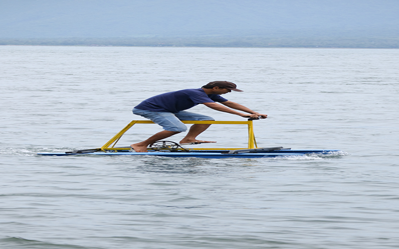 KREATIF: Miko Whelly mengayuh sepeda terapung rakitannya tak jauh dari Pantai Solong, Kecamatan Kalipuro, Banyuwangi, pada Januari 2017 silam.