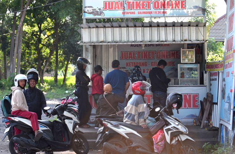 AGAR BISA MENYEBERANG: Calon penumpang kapal antre membeli tiket di salah satu kios di wilayah Kelurahan Bulusan, Kecamatan Kalipuro, Minggu (14/4).