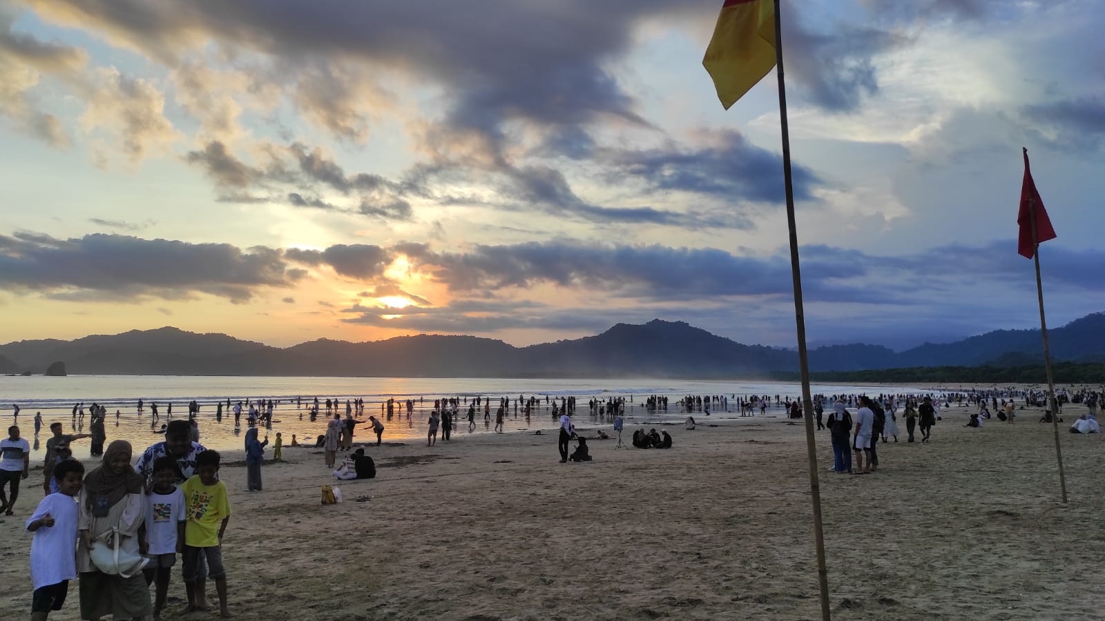 RAMAI: Ribuan pengunjung Pantai Pulau Merah Desa Sumberagung, Kecamatan Pesanggaran bermain air laut di pantai pada Minggu (14/4).