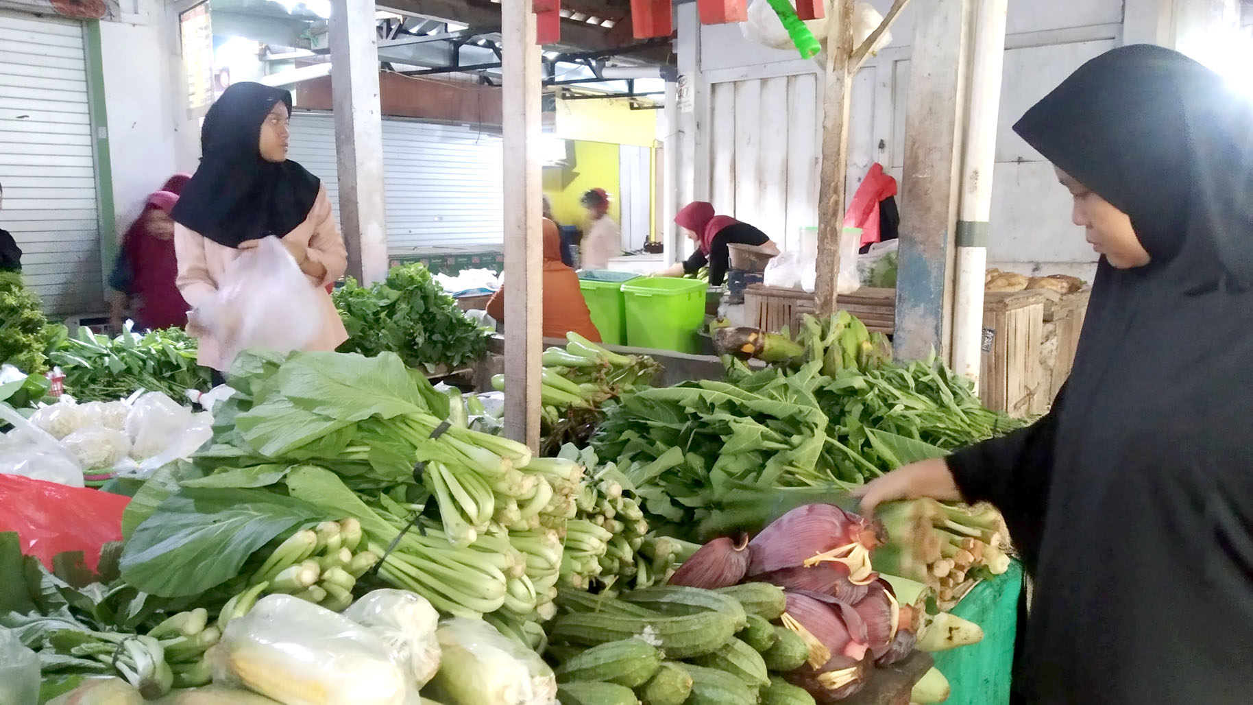 HIJAU-HIJAU: Siti Khotimah memilih sayuran hijau untuk dibeli di Pasar Genteng 2, Desa Genteng Kulon, Kecamatan Genteng Selasa (16/4).