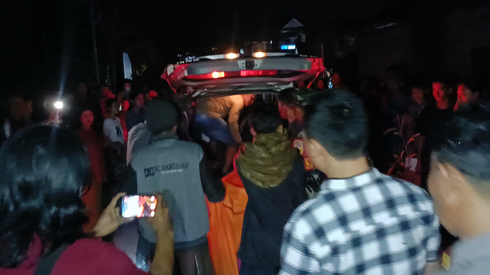 IDENTIFIKASI: Petugas mengevakuasi jenazah dari aliran sungai menuju mobil ambulans, Selasa malam (16/4)
