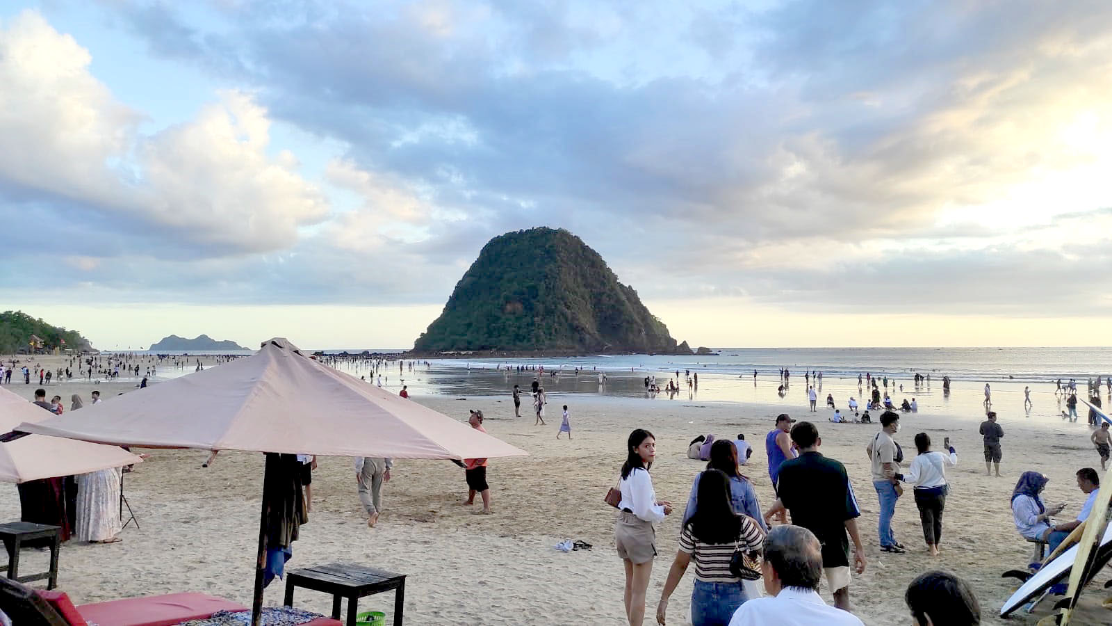 RAMAI: Pengunjung menikmati liburan di Pantai Pulau Merah, Kecamatan Pesanggaran, pada Minggu (14/4). Destinasi wisata pantai menjadi salah satu favorit wisatawan selama libur Lebaran tahun ini.