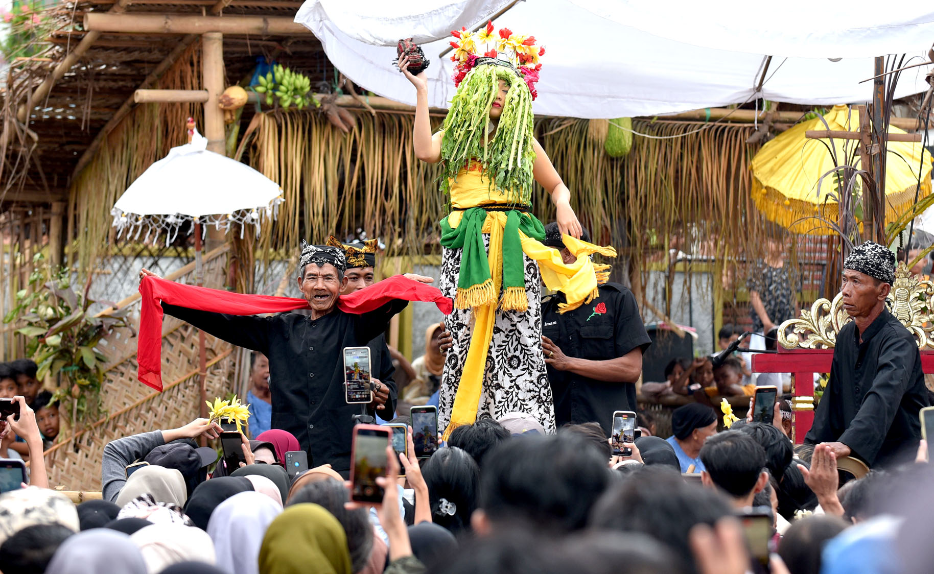 DAYA TARIK: Pengunjung mengabadikan momen saat Dwi Putri Ramadani menari seblang dalam kondisi mata terpejam.