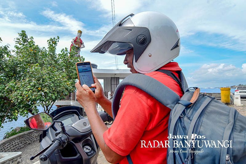 Pemudik membeli tiket penyeberangan Ketapang-Gilimanuk melalui aplikasi Ferizy di area icon Patung Gandrung Watudodol Banyuwangi. Aplikasi Ferizy memudahkan pemudik dalam melakukan perjalanan.