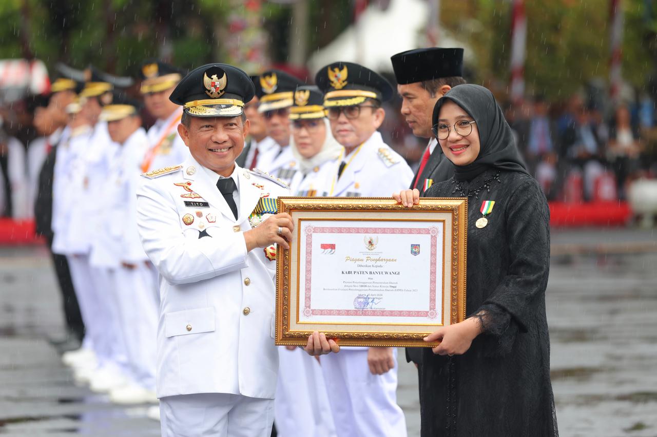 PENGHARGAAN TERTINGGI: Mendagri Tito Karnavian mewakili Presiden Jokowi menyerahkan Satyalancana Karya Bhakti Praja Nugraha kepada Bupati Ipuk Fiestiandani pada puncak peringatan Hari Otda XXVIII di S