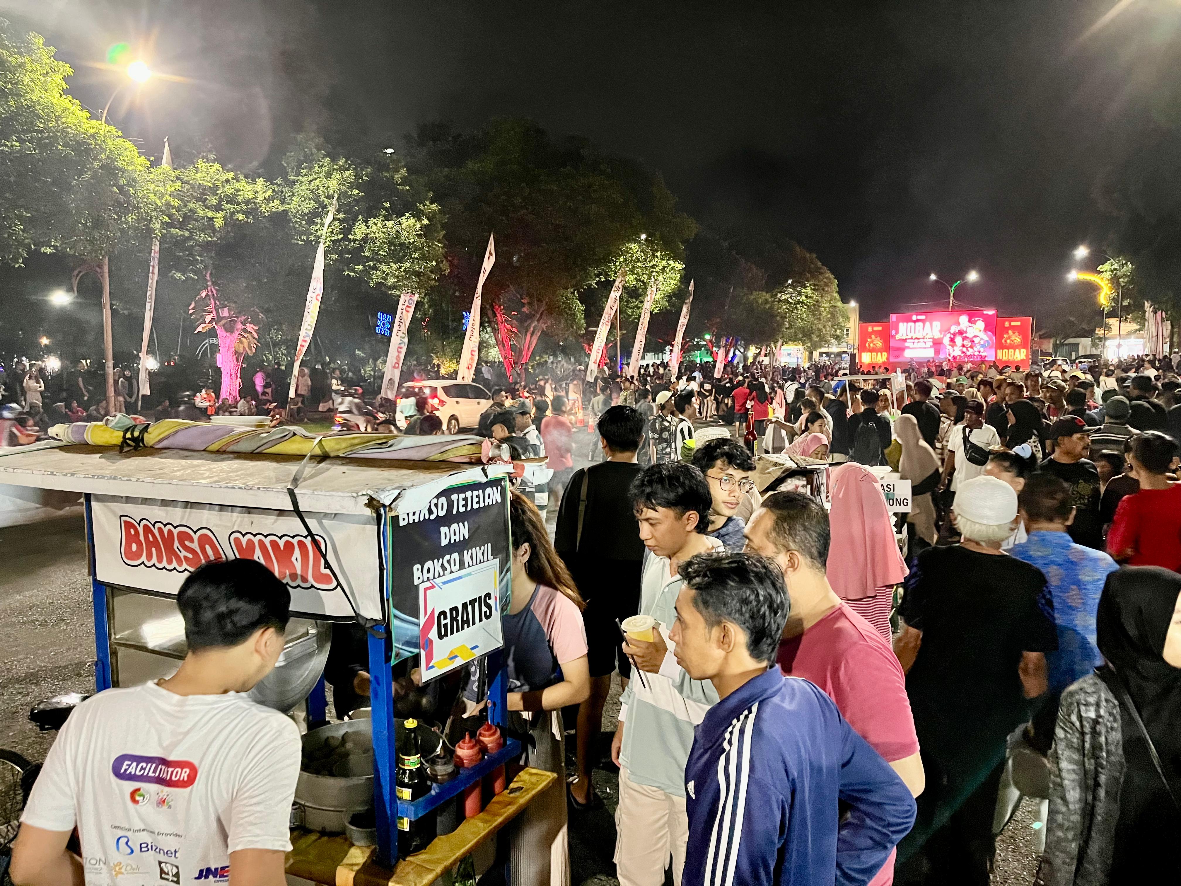 GRATIS: Warga yang akan nobar Timnas Indonesia di depan Pendopo Banyuwangi, mengantre makanan yang disediakan Pemkab secara gratis.