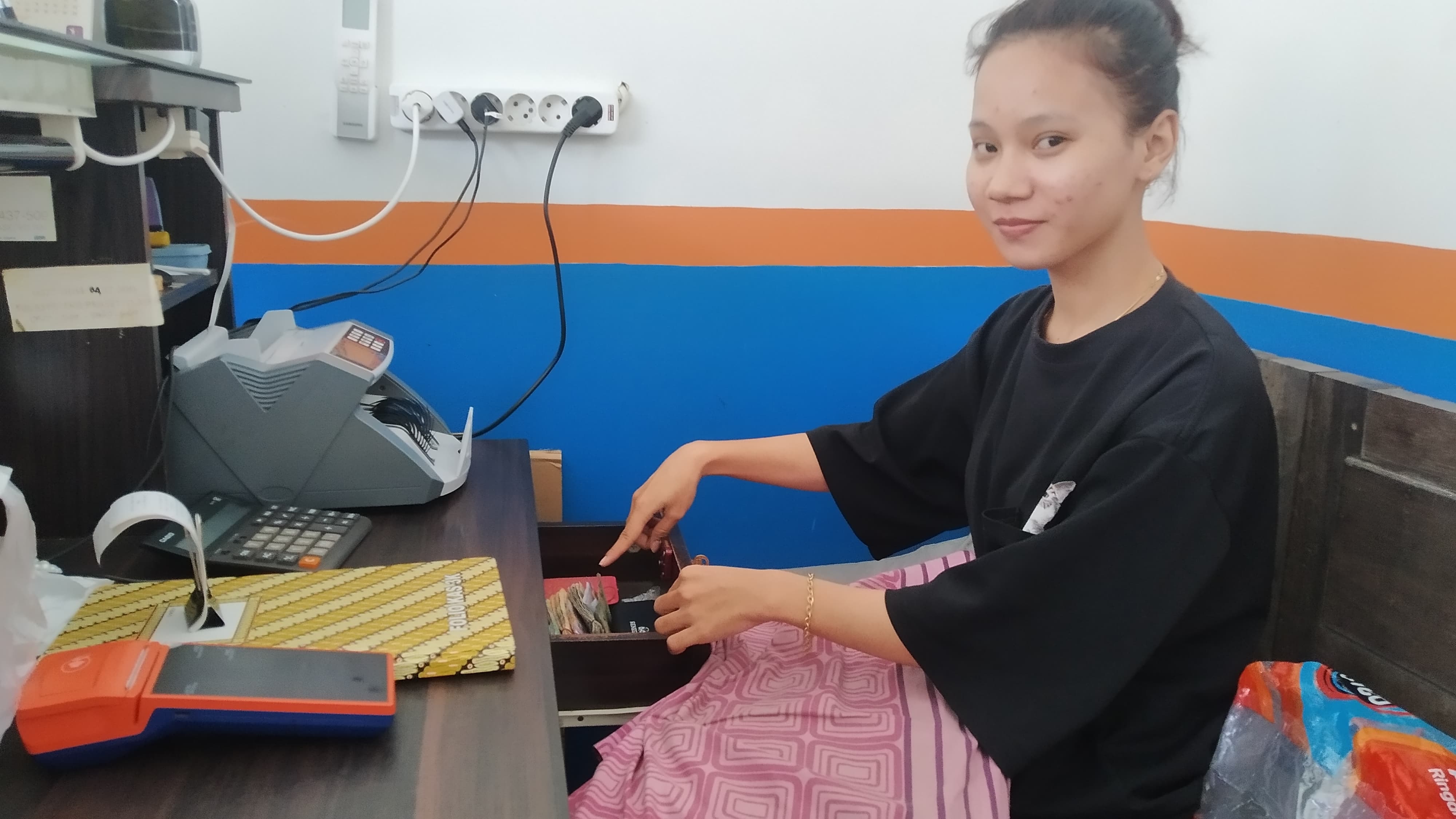 TKP: Nadia Salsabila menunjukkan laci uang yang diduga dicuri orang Turki di BRIlink Dusun Blokagung, Desa Karangdoro, Kecamatan Tegalsari Minggu (5/5).