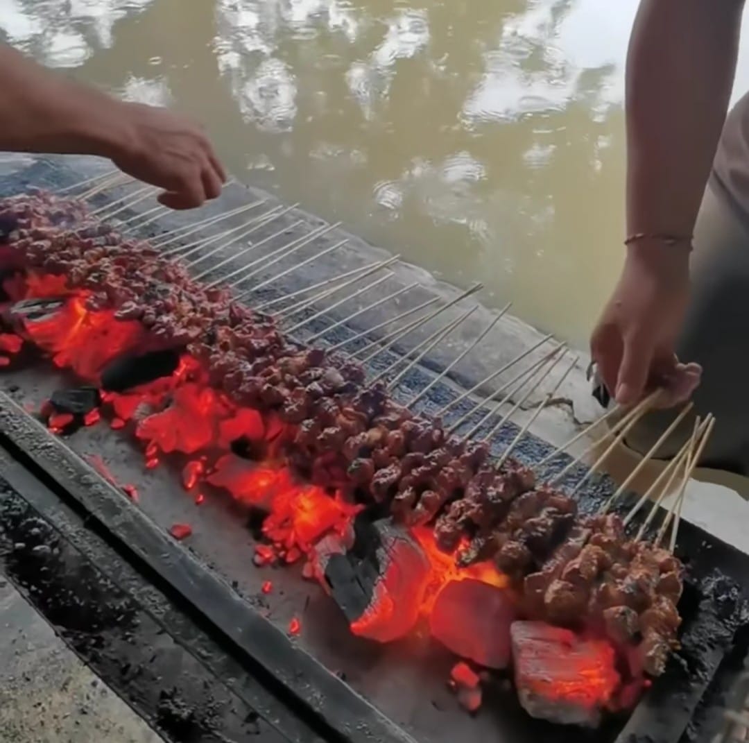 Sate kambing di Warung Lumayan Tegaldlimo, Banyuwangi berukuran besar-besar dibakar di tepi sungai.