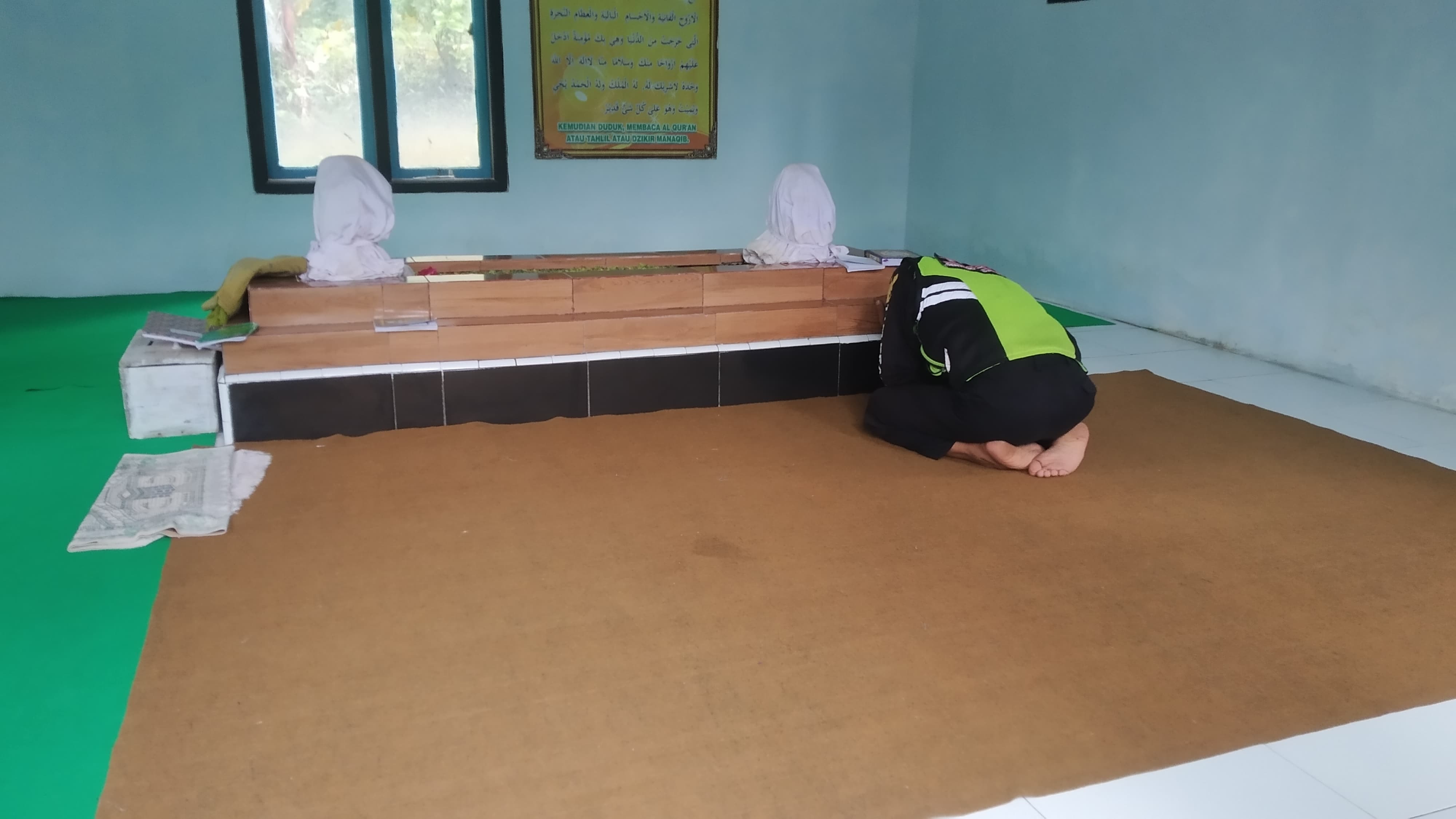 KHUSYUK: Salah satu peziarah terlihat berdoa di depan makam Mbah Kemis yang berlokasi di Dusun Krajan, Desa Kalibaru Manis, Kecamatan Kalibaru, Senin (6/5).