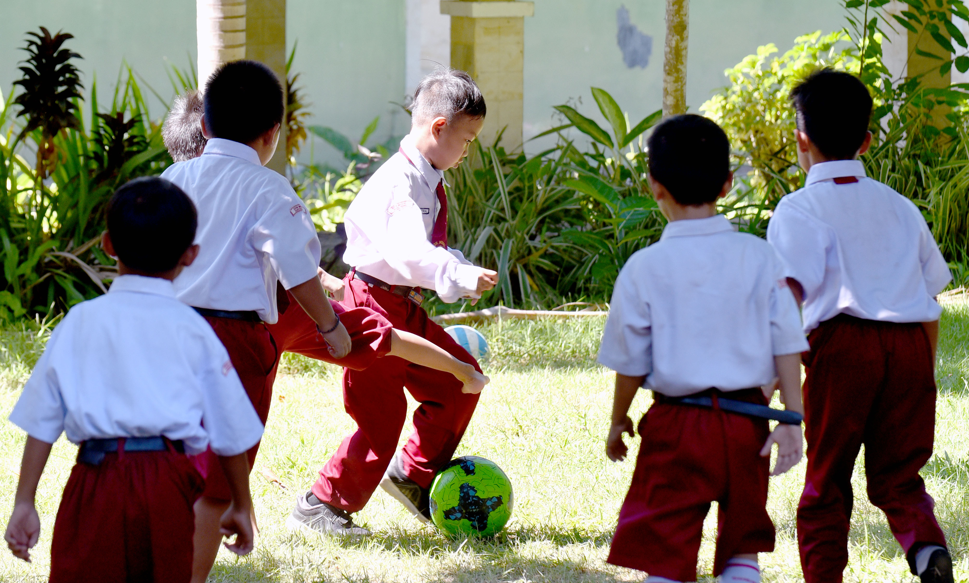BERMAIN DI SELA BELAJAR: Sejumlah siswa bermain sepak bola saat istirahat di SDN Model Banyuwangi.