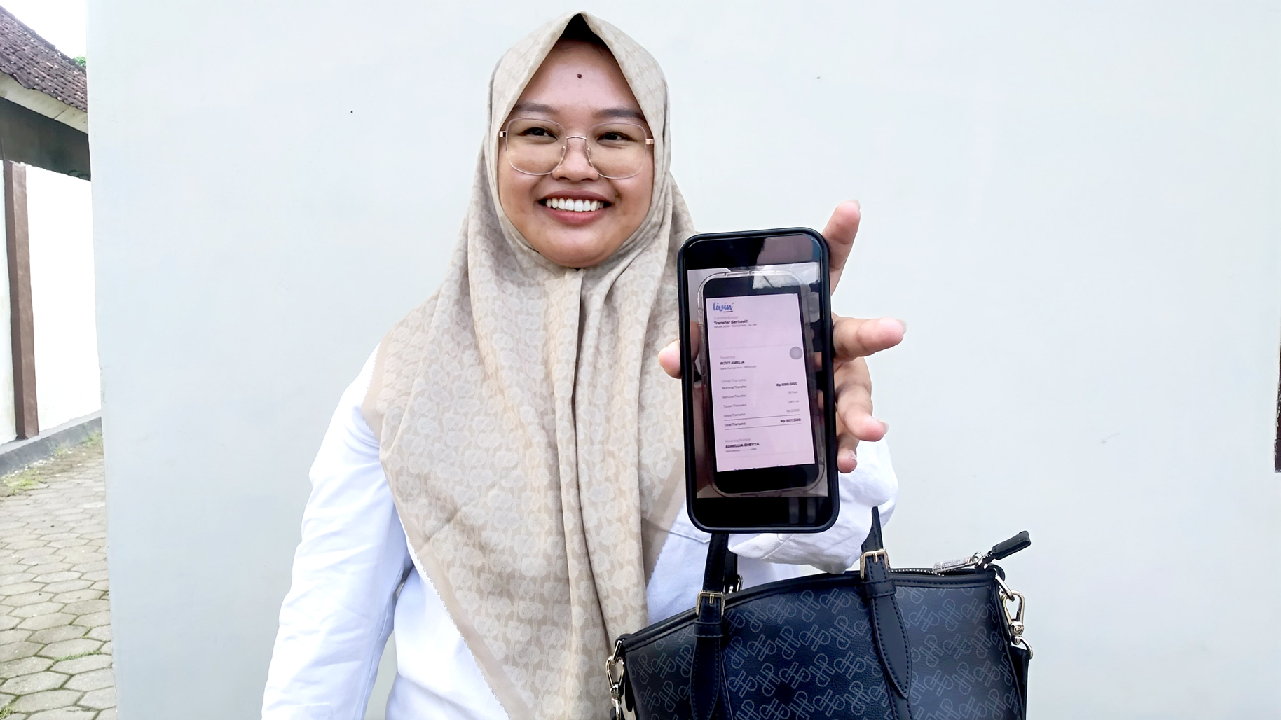 BARANG BUKTI: Rizky Amelia menunjukkan bukti transfer palsu setelah melaporkan kasus yang menimpanya ke Polsek Bangorejo Jumat (10/5).