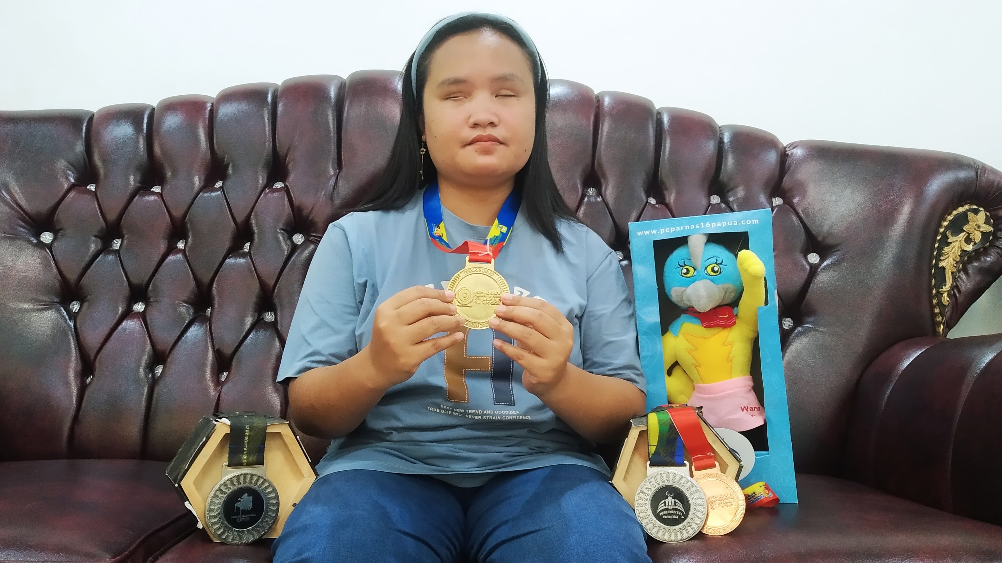 MEMBANGGAKAN: Reni Septianingrum menunjukkan berbagai medali yang diraih dalam ajang Peparnas dan Peparprov. Medali tersebut dipajang di ruang tamu rumahnya di Desa Karangharjo, Kecamatan Glenmore