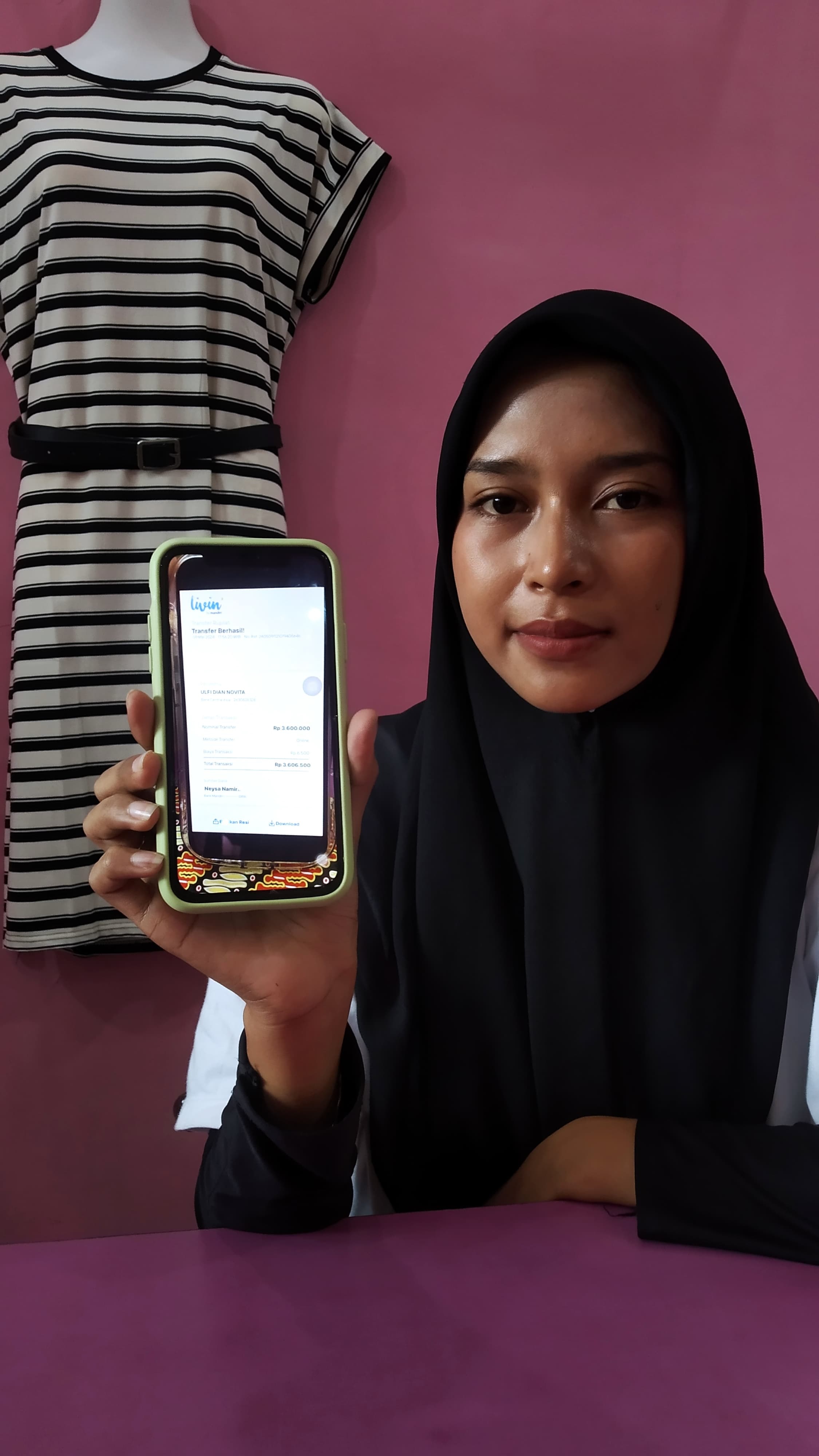 BUKTI: Oktavia Putri Puspita menunjukkan model gamis yang sama diambil pelaku di Butik Noona.daily di Dusun Sawahan, Desa Genteng Kulon, Kecamatan Genteng kemarin (13/5).