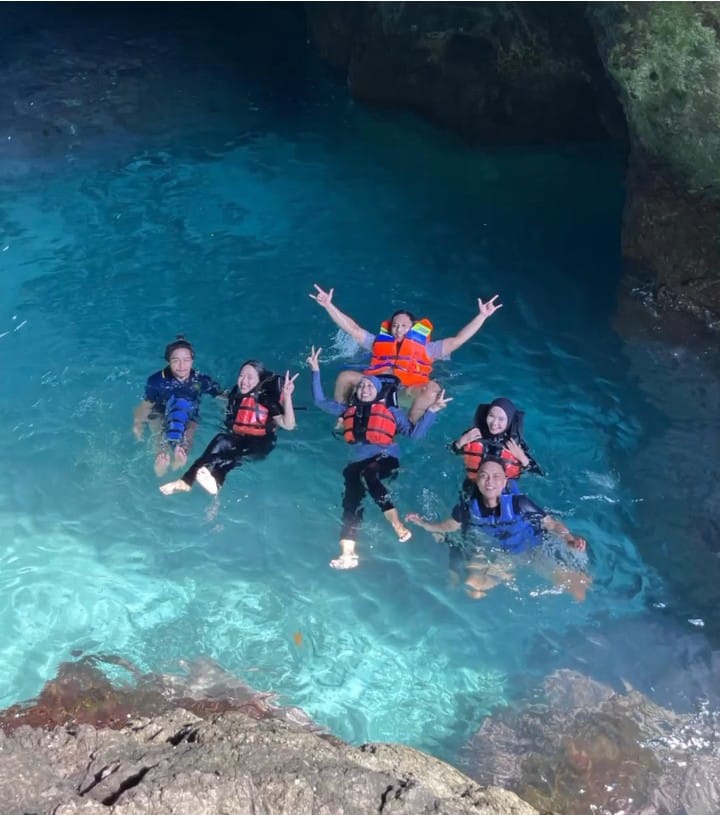 Wisatawan bisa berenang di air laut yang jernih di dalam gua di Pulau Bedil.