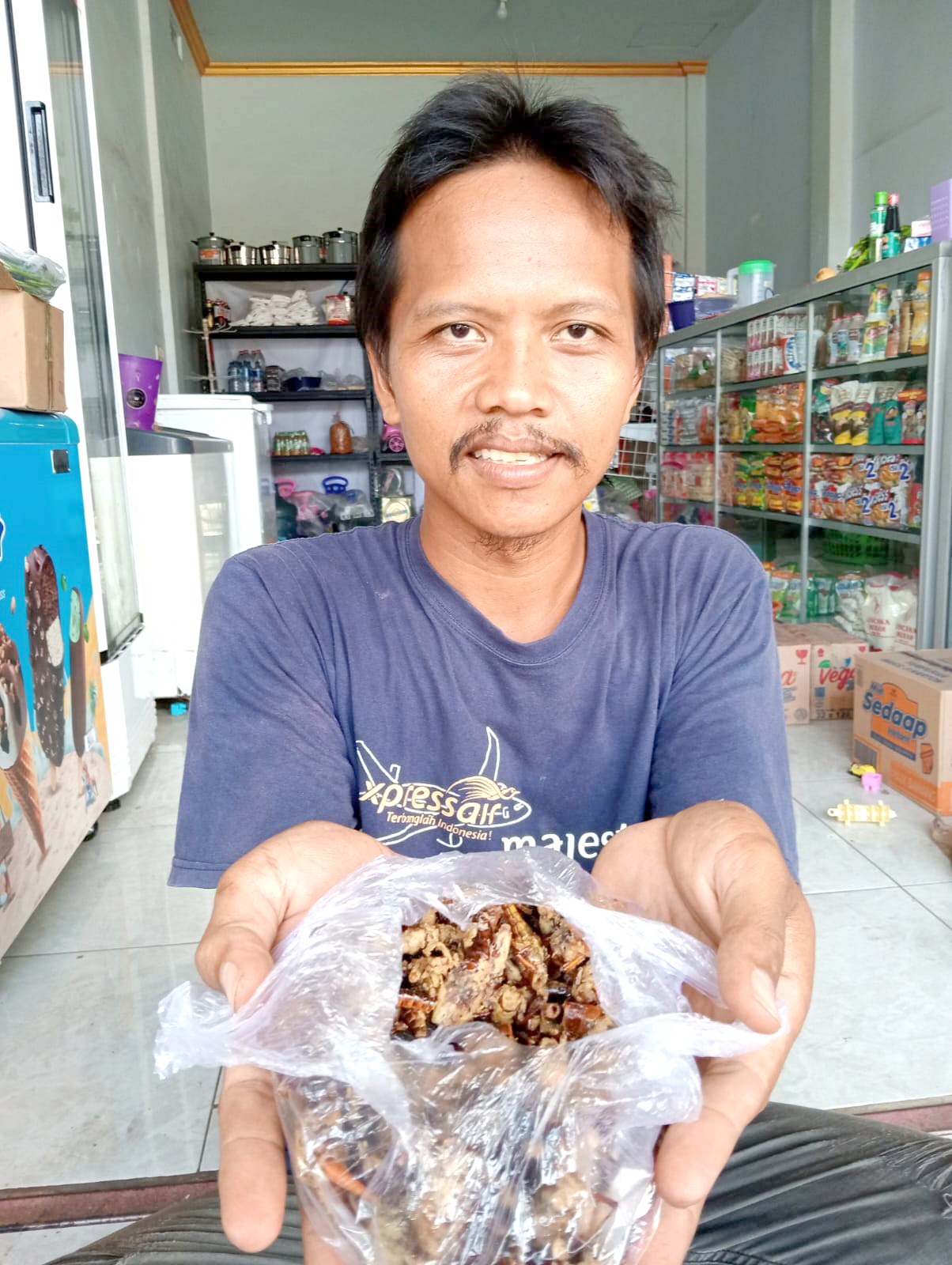 MAHAL: Pedagang belalang goreng Sulhan Hadi menunjukkan dagangannya di tokonya Dusun Curahjati, Desa Grajagan, Kecamatan Purwoharjo Jumat (24/5).