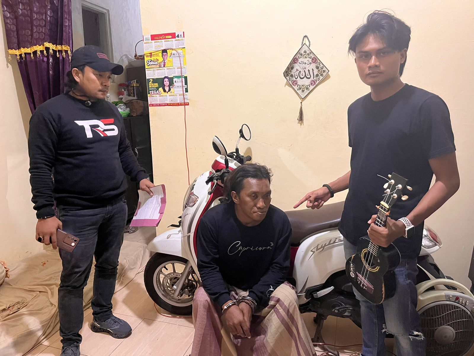 TERTANGKAP: Fredi Siswanto dengan tangan diborgol (tengah) diamankan polisi bersama motor Honda Scoopy milik Watini yang sempat dibawa kabur Minggu (26/5).