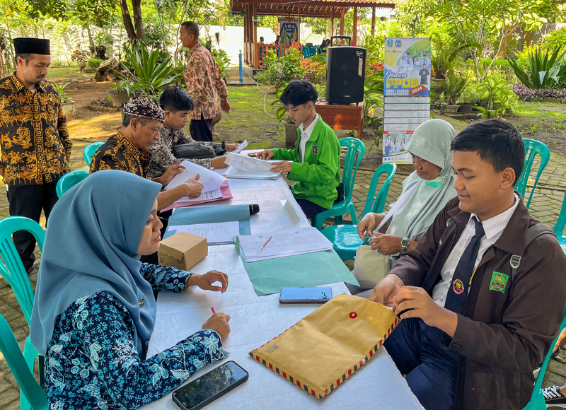 RAMADA KUSUMA/RABA  OUTDOOR: Pendaftar di SMAN 1 Glagah mengambil PIN dipandu operator sekolah setempat Senin (27/5).