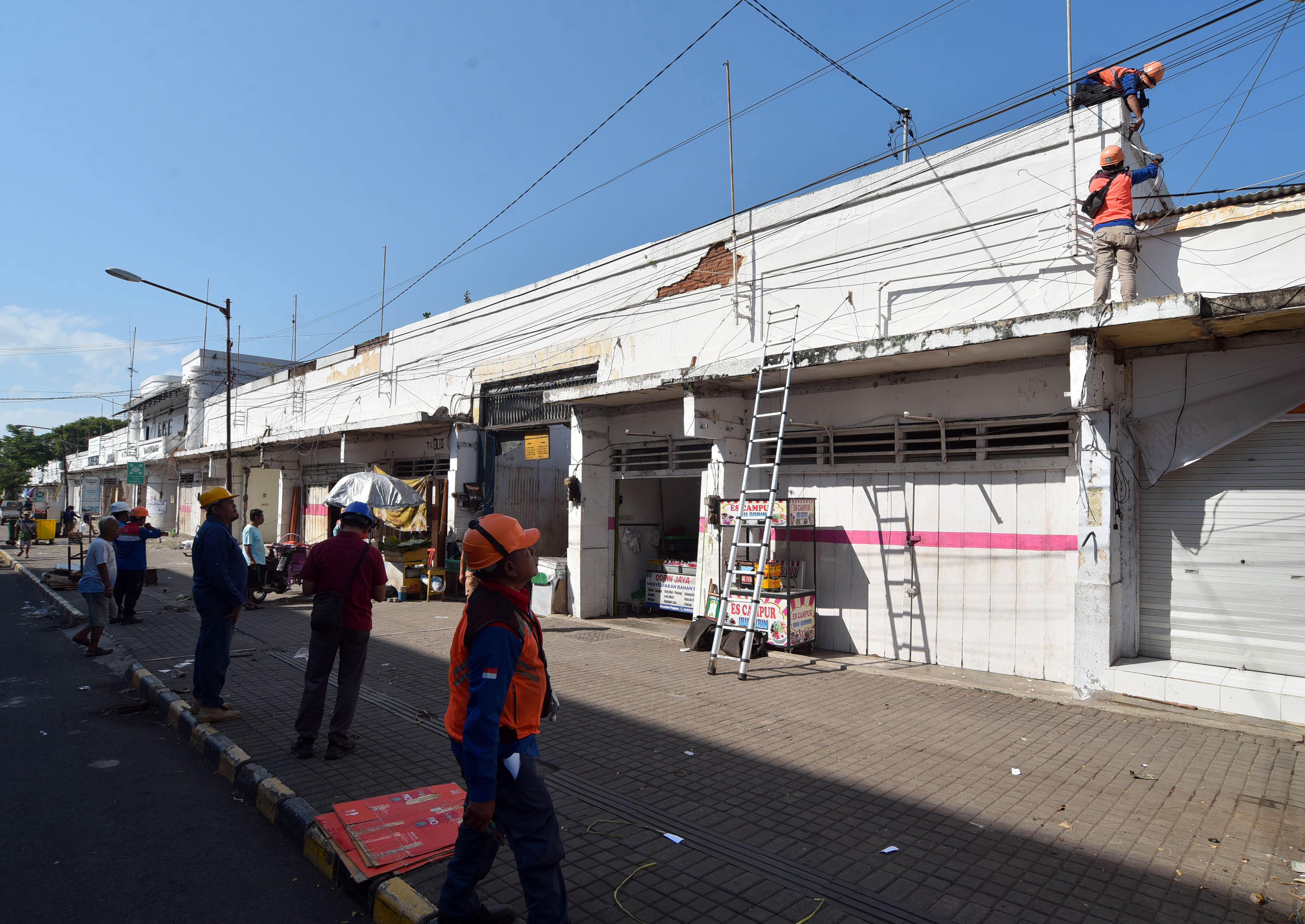 DITARGET TUNTAS 1 JUNI: Petugas PLN memutus jaringan listrik di kios-kios pedagang Pasar Banyuwangi. Pemutusan ini merupakan rangkaian dari revitalisasi Pasar Banyuwangi.&nbsp;